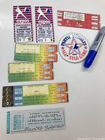 Photo showing Montreal Expos vintage tickets including Opening Day and Playoff tickets, an All-Star Game badge with Montreal Expos logo, and a black Sharpie marker