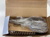 Open cardboard box showing plastic-wrapped beaters and coiled power cord inside.