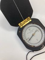 Opened octagonal compass showing dial branded Keuffel & Esser Co. with brass hinge detail.