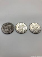 Reverse side of three 1971 British Columbia silver dollars showing the British Columbia coat of arms.