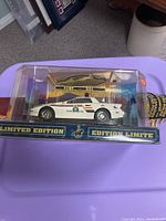Front view of sealed RCMP model car and one shoulder patch in original box with 'Limited Edition' label.