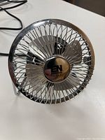 Front view showing metal wire cage, metal blades, and center label with 'EN' and 'NEEDS' text.