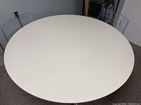 Top view of white round table with chairs partially visible around it