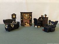 Overall view of miniature Avon Victorian Memories living room furniture set including couch, armchair, roll-top desk with chair, fireplace with dog figurine, and accessories.