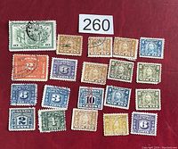 Photo displaying 19 assorted Canada excise and postage stamps on a red background, showing various denominations and cancellation marks.