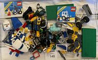 Top view of assorted LEGO pieces spread out showing two instruction manuals, many bricks, wheels, and other parts.