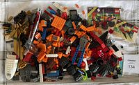 Photo showing a large pile of mixed LEGO pieces including bricks, vehicle parts, wheels, and instruction booklets for sets 6896 and 6877.