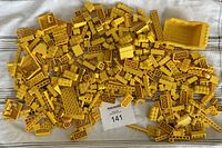 Photo of many various yellow LEGO pieces spread out showing a diverse assortment of bricks, plates, window components, and other pieces.