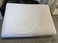Full view of mattress covered with a light-colored fitted sheet showing size and condition.