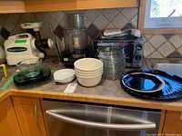 Wide view showing assortment of bowls and plates arranged on kitchen counter next to appliances
