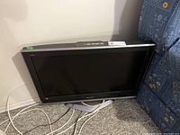 Front view of Panasonic 32-inch flat-screen TV with cables, no remote present.