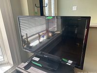 38-inch Philips television front view showing screen and attached stand base on a wooden surface.