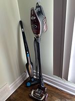 Two vacuums side by side, Shark Rocket Deluxe Pro upright vacuum with cord and Electrolux Ergorapido stick vacuum.