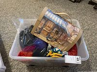 Plastic bin containing yarn, unfinished projects and decorative storage box.