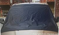 Photo showing the magnetic cover positioned on a car windshield, covering full windshield surface in deep blue color.
