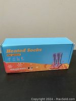 Box of thermal heated socks labeled for winter use with blue top and orange bottom showing sock illustration.