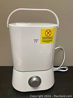 Front view of white ultrasonic cool mist humidifier showing integrated handle and rotary control knob on base.