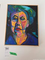Full view of the framed painting showing the entire colorful abstract portrait on canvas with a wooden frame.