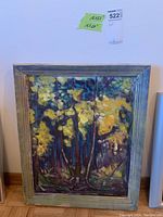 Frontal view of the painting in its rustic wooden frame showing colorful trees and leaves in an impressionistic style.