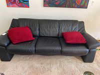 Front view of full sofa with two red cushions