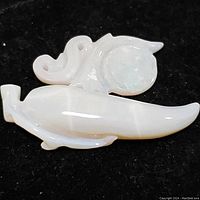 Close-up front photo of the carved opal pendant showing smooth white opal with round translucent orb detail.