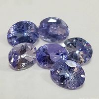 Close-up photo of five oval-cut tanzanite gemstones showing color and facets.