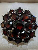 Close-up front view of the sterling silver garnet ring showing the multiple garnet stones set in a clustered flower-like design.