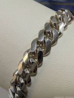 Close-up view of the sterling silver bracelet showing the polished flat links.