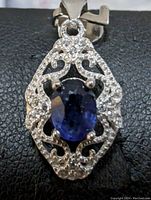 Close-up front view of the pendant showing the sapphire and cubic zirconia