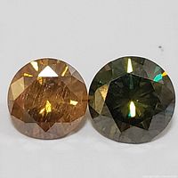 Two round faceted gemstones side by side, one golden brown and one dark green