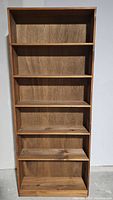 Front view of the six shelf wood bookcase showing the even spacing of shelves and natural wood grain.