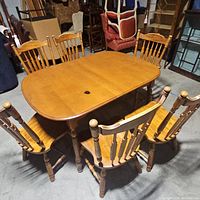 Top view of wooden dining table with six matching chairs arranged around it.