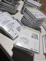 Box of assorted Stampin' Up! photopolymer stamp sets arranged in stacks, showing cases with florals and greetings.