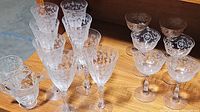 Top view showing grouped stemware: wine glasses, champagne coupes, and a small creamer or pitcher on a wooden surface.