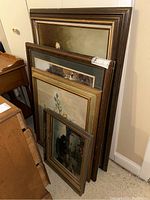 Four framed artworks leaning against wall