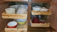 Full view of cabinet drawers showing variety of bowls, plastic containers, silicone lids, and casserole dishes.