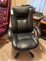 Front view of black adjustable office armchair showing padded seat, backrest and armrests with wheels under base.