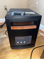 Front view of the EdenPURE portable heater showing the front temperature control panel, wooden accent handle, and power cord.