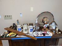 View of assorted Duke University steins, figurines, and decorative items arranged on wooden table.