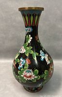Front view of a vintage Chinese cloisonné enamel vase showing floral patterns and brass rim top