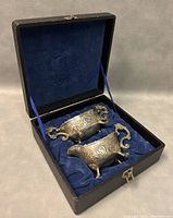 Silver plated creamer and sugar bowl set inside original box with blue velvet lining.