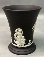 Front angled view showing classical female and child white relief design on black basalt jasperware vase.