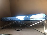 Foldable cot frame with air mattress installed, side view