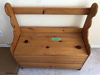 Full front view of wooden entrance storage bench showing seat and backrest, natural wood finish, with some visible knots and marks.