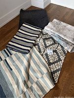 Six assorted floor mats and runners with different patterns and textures arranged on floor.