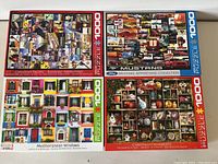Four 1000-piece puzzles arranged in grid showing box top images and themes