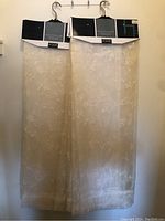 Two of the sheer curtain panels hanging with original packaging showing.