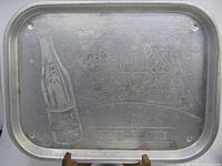 Full view of the aluminum beer tray showing embossed bottle and text design