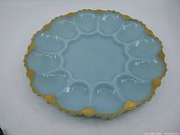 Top view of the robin egg blue devilled egg plate showing twelve egg-shaped wells and scalloped gold-trimmed edge