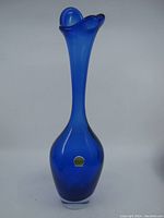 Full view of tall cobalt blue glass vase with flared wavy top and narrow neck